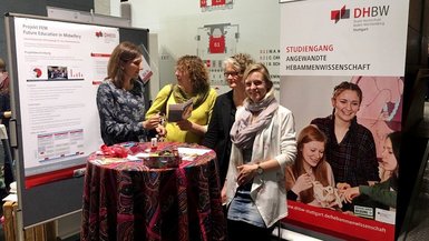Sonja Wangler, wissenschaftliche Mitarbeiterin (links im Bild) und Miriam Jubitz und Miriam Skowronek, Studentinnen im FEM Studiengang (rechts im Bild) an der DHBW Stuttgart, im Gespräch mit einer Kongressteilnehmerin.