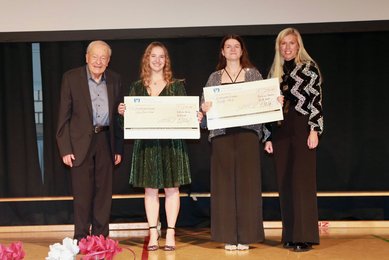 Bachelorfeier 2024: Alina Marie Esser und Emma Barbara Weiß nehmen aus den Händen des gleichnamigen Stifters und von Carolin Schwenk den Helmut-Günther-Preis für ihr vorbildliches soziales Engagement entgegen.