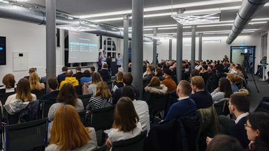 Studierende des Studiengangs BWL-Handel präsentieren TikTok-Konzepte bei Social Media Night Stuttgart. Voll besetzter Saal - Das Foto wurde in Richtung Bühne aufgenommen, die Zuschauer*innen sind von hinten zu sehen.
