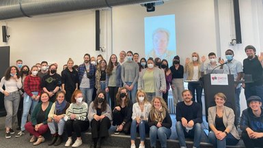 Gruppenfoto mit den Besucherinnen und Besuchern der Veranstaltung vor der Bühne.