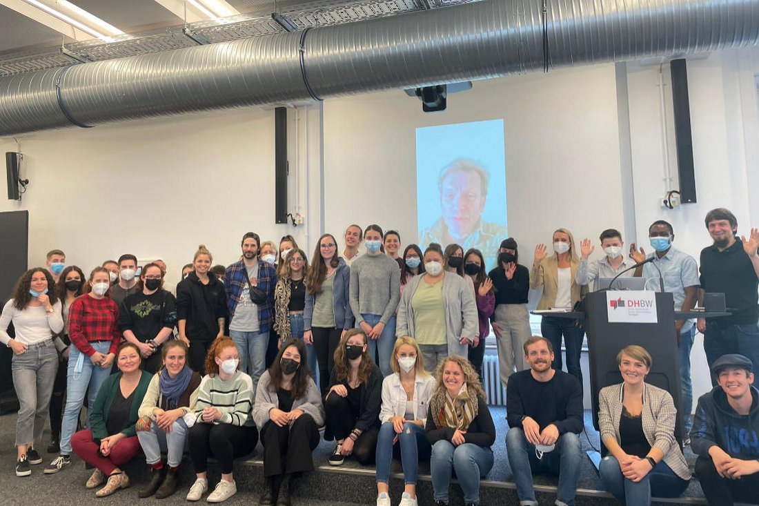 Gruppenfoto mit den Besucherinnen und Besuchern der Veranstaltung vor der Bühne.