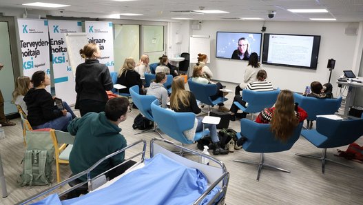 Workshop-Teilnehmende schauen auf einen großen Monitor. 