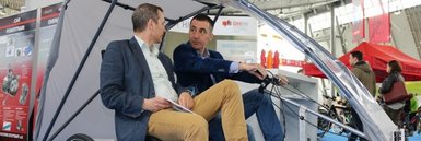 Prof. Mandel und Cem Özdemir MdB mit dem EduMotion-Fahrzeug auf der i-mobility-Messe