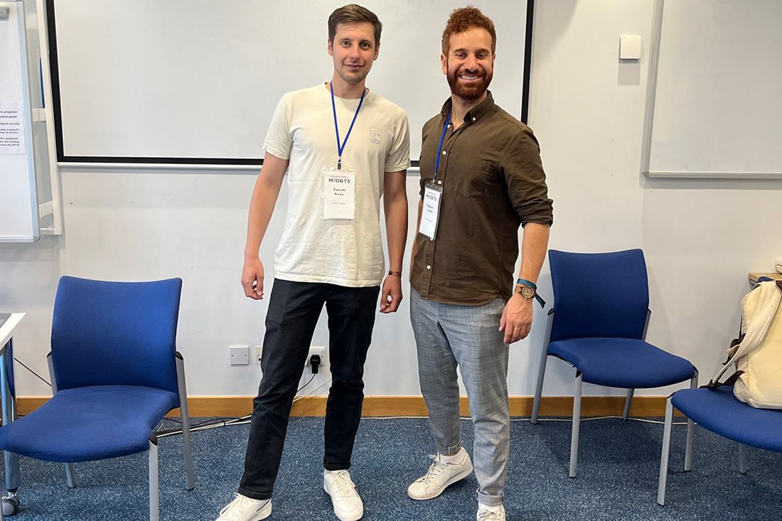 Yannik Knau und Robert Lahdo stehen nebeneinander in einem Seminarraum.