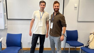 Yannik Knau und Robert Lahdo stehen nebeneinander in einem Seminarraum.