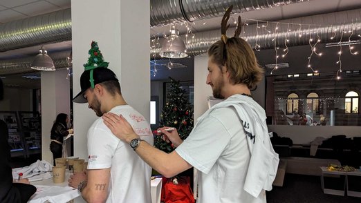Ein Teilnehmer dreht sich um, damit ein anderer Teilnehmer sein T-Shirt auf dem Rücken unterschreiben kann.