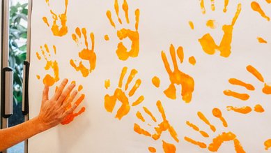 Großaufnahme der orangefarbenen Handabdrücke.