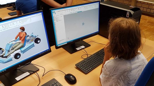 Konzentrierte Arbeit am PC Blick über die Schulter eines Kindes, das vor zwei Computerbildschirmen sitzt.