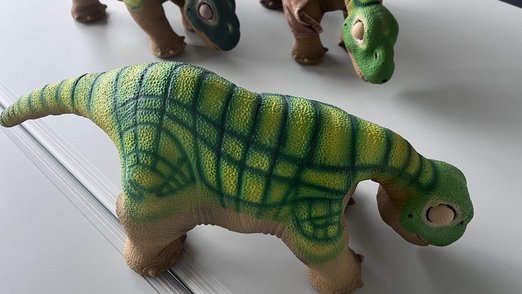 Drei Dinosaurier aus Kunststoff stehen auf einem Tisch - Diese bewegen sich, wenn man sie berührt.