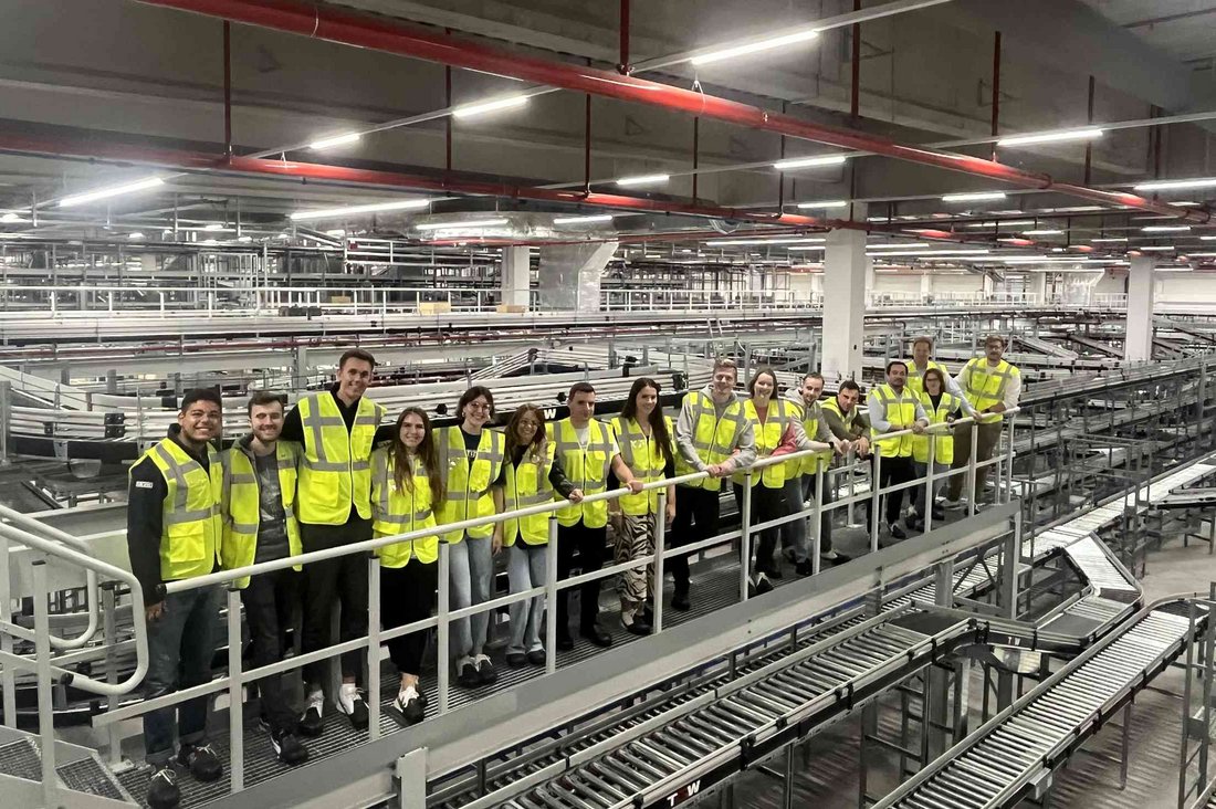 Gruppenfoto mit Studierenden in einer der Werkshallen