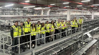 Gruppenfoto mit Studierenden in einer der Werkshallen