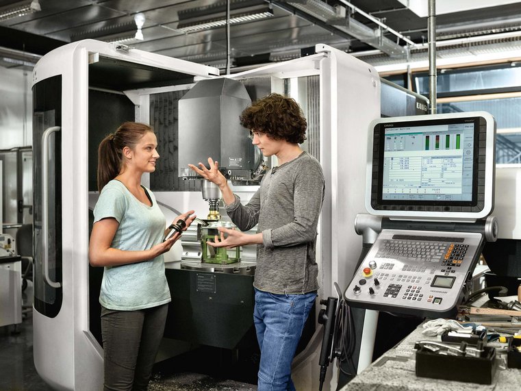 Studierende vor Fräsmaschine beim Diskutieren