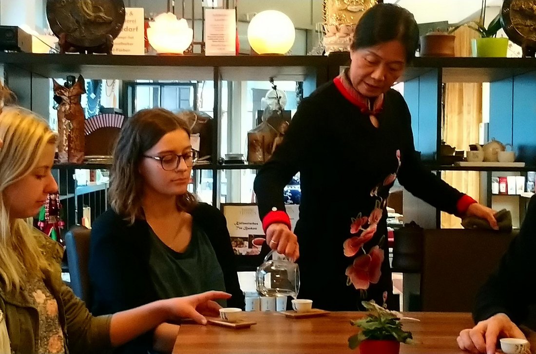 Teemeisterin Aimin Wagner schenkt Tee an Studierende aus.