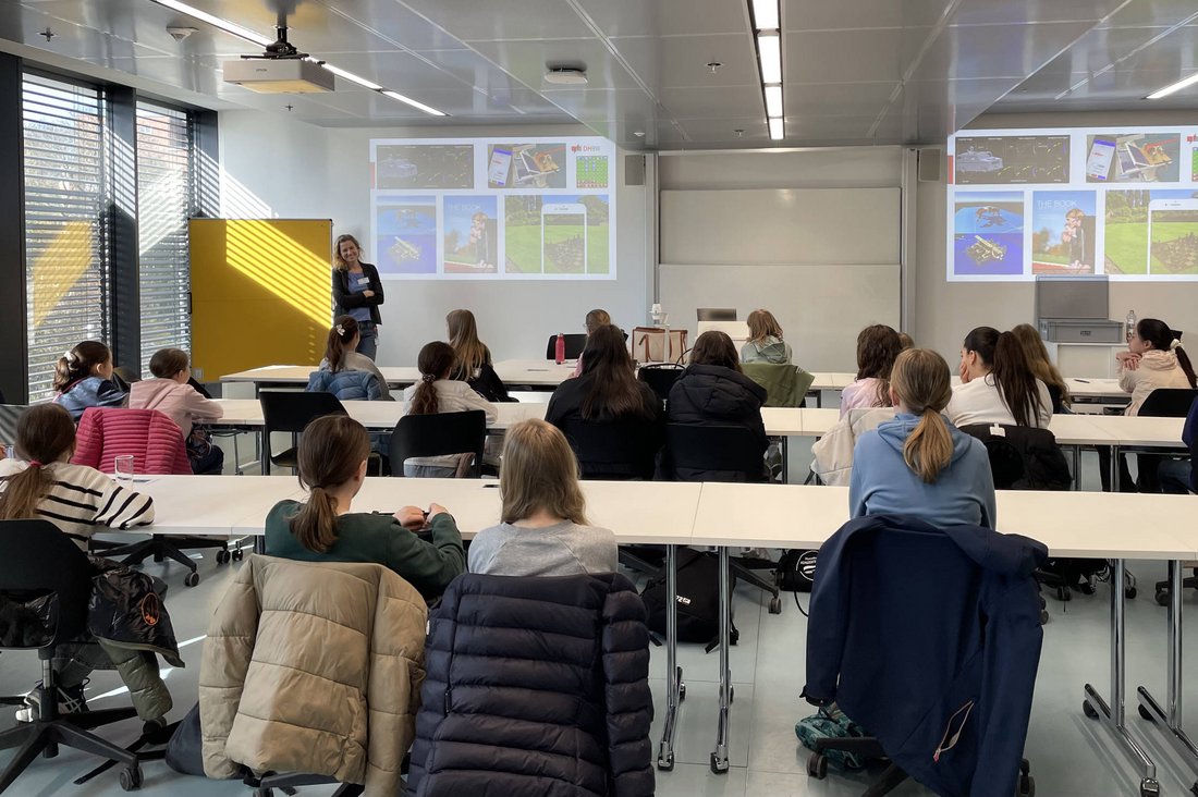 Prof. Dr. Monika Kochanowski steht vor den Schülerinnen und begrüßt diese. 