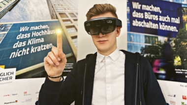 Student mit Brille vor Plakaten