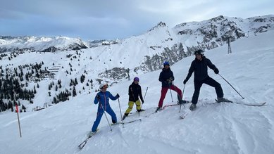Gruppenfoto mit 4 Teilnehmenden auf der Ski-Piste