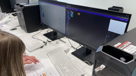 Detail-Ansicht eines der Computer-Bildschirme, vor dem eine Teilnehmerin sitzt.