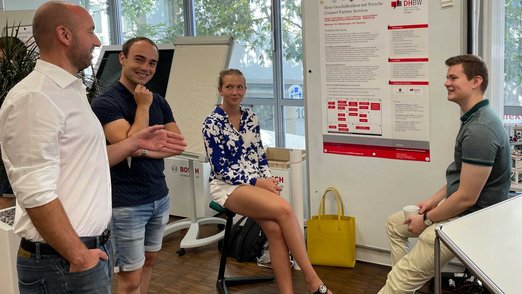 Studierende während einer Posterpräsentation 