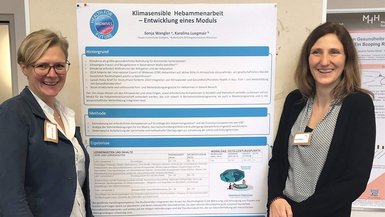 Karolina Luegmair und Sonja Wangler präsentieren ein Plakat.