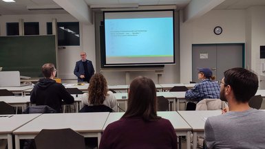 Teilnehmende beim Vortrag über nachhaltiges Banking an der DHBW Stuttgart Vortrag über nachhaltiges Banking an der DHBW Stuttgart: Teilnehmende sitzen an Tischen und schauen nach vorne zum Vortragenden.