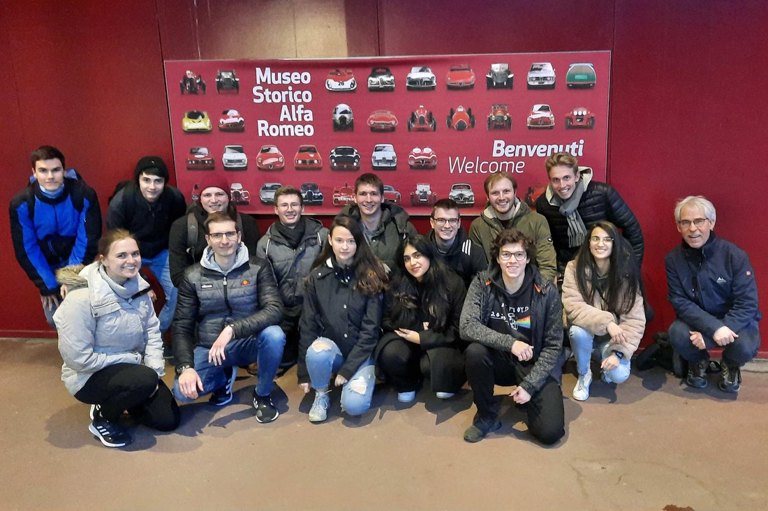 Gruppenbild vor einem Plakat des Museo Storico Alfa Romeo