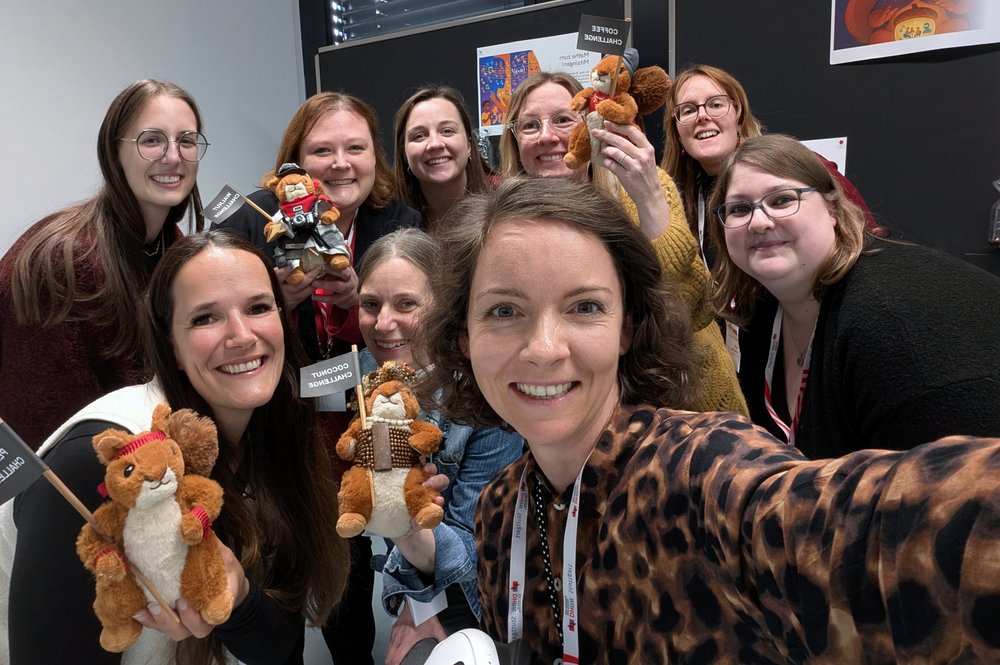 Ein Gruppenselfie der Teams von Bibliothek, Hochschulsport und Education Service Center. Mit im Bild die 4 Plüsch-Eichhörnchen.