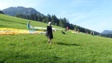 Teilnehmende des DHBW-Schnupperkurses Gleitschirmfliegen während der Übungen am Übungshang. 