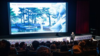 Prof. Dr. Uwe Swoboda begrüßt das Publikum zur Filmpremiere des Studiengangs BWL-Dienstleistungsmanagement mit Schwerpunkt Media, Vertrieb und Kommunikation der DHBW Stuttgart Prof. Dr. Uwe Swoboda begrüßt das Publikum zur Filmpremiere des Studiengangs BWL-Dienstleistungsmanagement mit Schwerpunkt Media, Vertrieb und Kommunikation der DHBW Stuttgart
