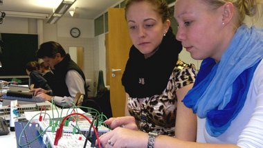 Zwei Studentinnen bauen im Labor Elektrotechnik eine Schaltung mit Logik- und Speicherbausteinen auf.