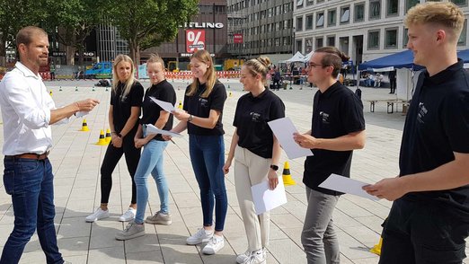 Prof. Dr. Marc Kuhn mit Studierenden auf dem Marktplatz