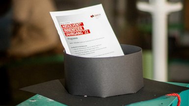 Nahaufnahme eines der Bachelor-Hüte mit einem Programmzettel.