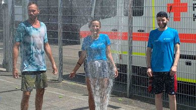 Eine Wasserfontäne spendet einigen Läuferinnen und Läufern Abkühlung.