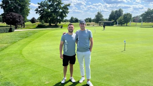 Die Studierenden Maxim Ament und Henri Ohlsen stehen auf dem Golfplatz.