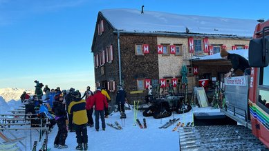 Gruppenbild im Schnee vor einer Berghütte