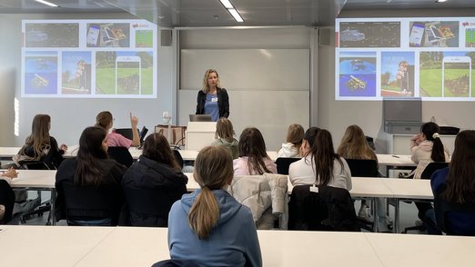 Die Schülerinnen hören einem Vortrag aufmerksam zu.