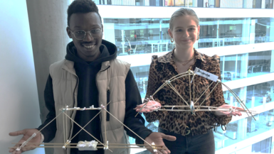 Die Studierenden Lena Falkenstein und Jean Ododa von WIW-FM mit Beispielergebnissen der Brückenbau-Challenge