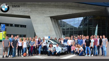 Logistik-Studierende mit Studiengangsleiterin Prof. Dr. Beate Sieger Hanus und Studiengangsleiter Prof. Dr. Dirk Hartel (kniend vor dem Auto)